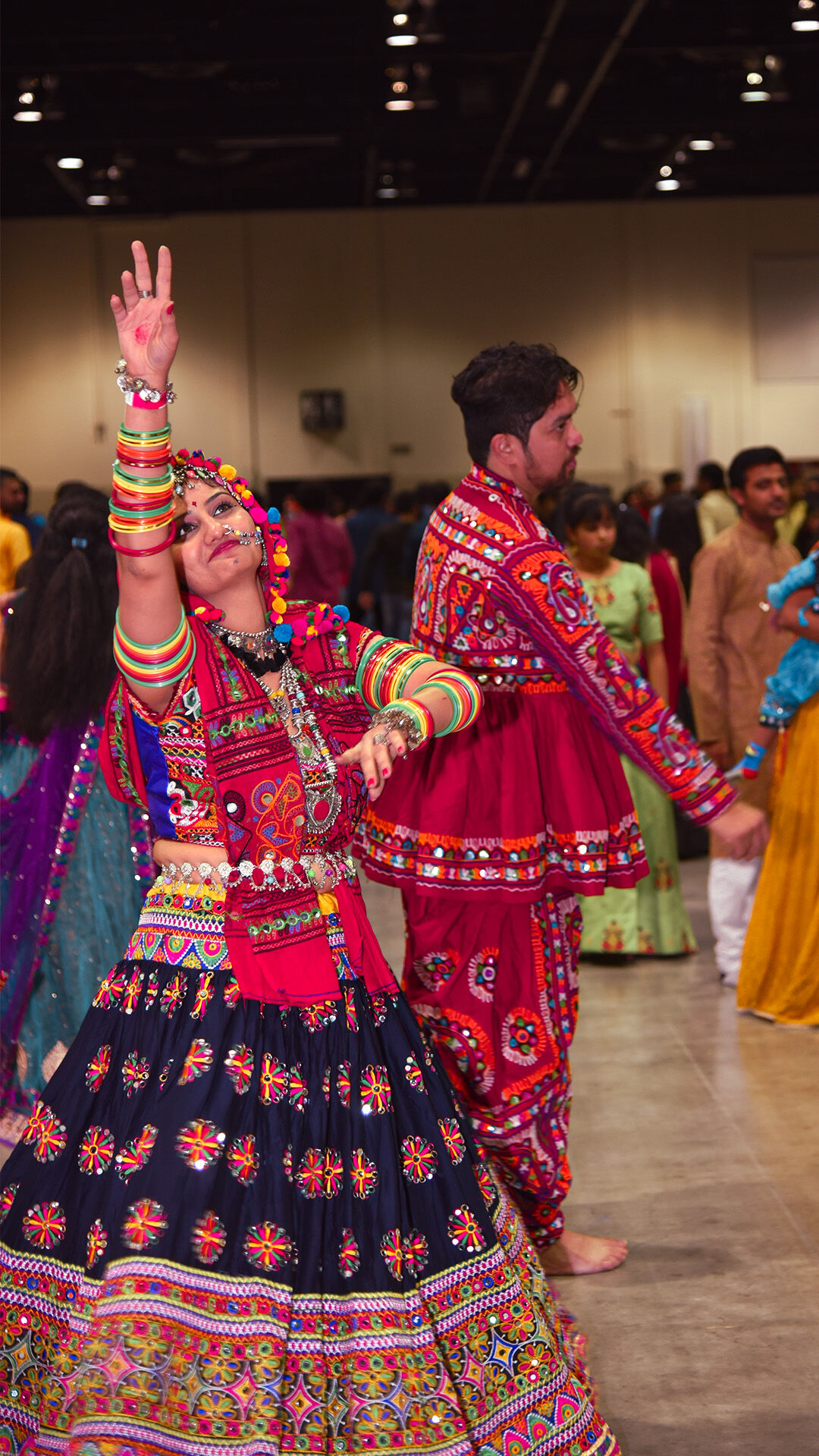 Men and women in traditional colorful attire performing Garba dance during Navratri celebration